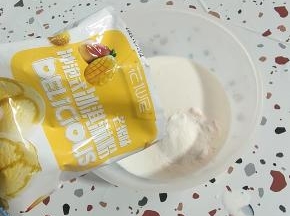 另取一个碗，倒入1包纯牛奶，再放入一包芒果味冰淇淋粉！