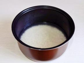 米淘好倒入电饭煲中焖饭。