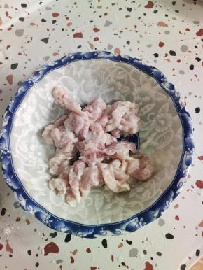 再加入适量的清水，给它稀释开！然后把肉片给它抓至浓稠，尽量抓的干一些！这样在炸的时候，它不容易脱糊！