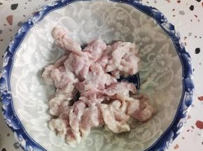 再加入适量的清水，给它稀释开！然后把肉片给它抓至浓稠，尽量抓的干一些！这样在炸的时候，它不容易脱糊！