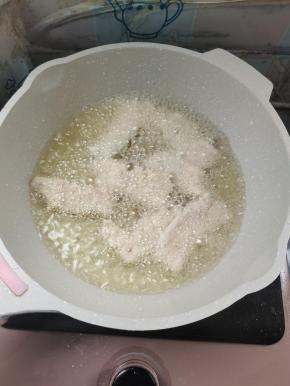 把锅包肉一片一片的下锅炸！（下锅包肉往前扔，这样炸，它不容易崩手，锅包肉一次不要下得太多，下多了容易粘连！分批往锅里下，这样就可以避免粘连在一起！）