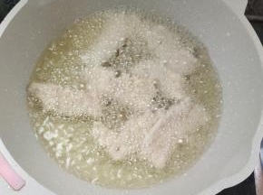 把锅包肉一片一片的下锅炸！（下锅包肉往前扔，这样炸，它不容易崩手，锅包肉一次不要下得太多，下多了容易粘连！分批往锅里下，这样就可以避免粘连在一起！）