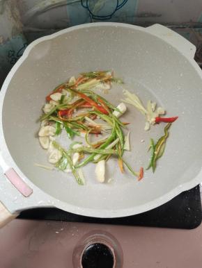 锅中留少许底油，放入蒜瓣，姜丝，辣椒丝给它爆香！