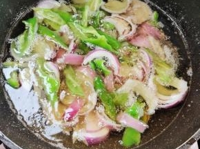 再把洋葱和青椒放入油锅中过一遍油，捞出控干油分备用！