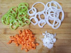 准备馅料：青椒切成圈，洋葱先切成圈，取出中间部分切成小丁，胡萝卜切成小丁。 