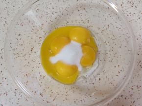 给蛋黄里面加入15g的细砂糖，用手动打蛋器搅打均匀。 
