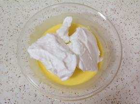 打发好的蛋白取三分之一加入到蛋黄糊里面，用硅胶刮刀采用切拌和翻拌的方法混合均匀。 
