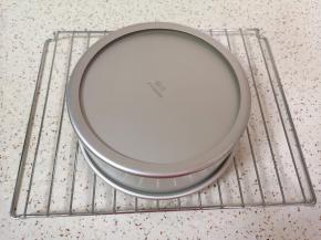 时间到，从烤箱里取出蛋糕，垂直摔一下震出热气，倒扣在晾网上，凉透之后脱模。 