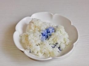 米饭盛入盘中，倒入蝶豆花水，抓拌均匀。