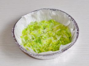 取一耐高温圆盘，垫上油纸，加入包菜丝铺平。
