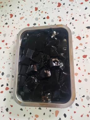 一包烧仙草粉倒入盘子里，再倒入1000克沸水，搅拌均匀，彻底晾凉后就会凝固了！用刀换成小块备用！