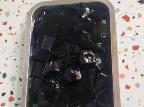 一包烧仙草粉倒入盘子里，再倒入1000克沸水，搅拌均匀，彻底晾凉后就会凝固了！用刀换成小块备用！