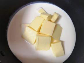 奶锅里倒入淡奶油，加入细砂糖、盐和黄油块。 