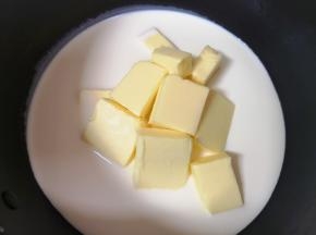 奶锅里倒入淡奶油，加入细砂糖、盐和黄油块。 