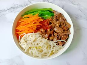 米饭放碗里，加上豆芽，胡萝卜，菠菜牛肉拌饭酱，拌均匀即可食用。