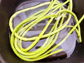 锅里烧水，水开后放入豆角焯至断生