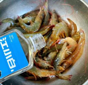 倒入适量白酒轻轻按摩使每只海虾都难裹上白酒这样既杀菌又有一种酒的香味盖上保鲜膜放入冰箱冷藏半小时