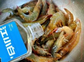 倒入适量白酒轻轻按摩使每只海虾都难裹上白酒这样既杀菌又有一种酒的香味盖上保鲜膜放入冰箱冷藏半小时