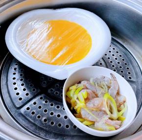 蛋液盖上保鲜膜和煨制入味的鲜虾放入蒸锅大火蒸十五分钟