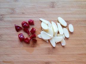 大蒜切成片，干红辣椒切成段。 