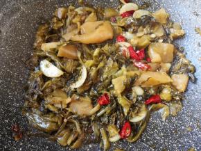 下入酸菜鱼调料里面的酸菜，翻炒至酸菜里面的水分挥发。