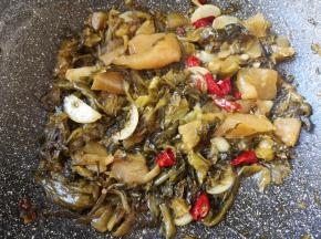 下入酸菜鱼调料里面的酸菜，翻炒至酸菜里面的水分挥发。