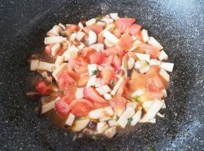 下入豆腐干和西红柿，翻炒至出汁。 