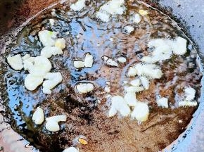 锅中倒入底油加热放入花椒炸香再放入蒜粒爆香