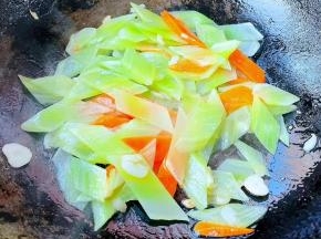 放入莴笋和胡萝卜片炒匀