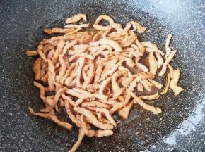 锅内倒适量的食用油烧热，下入腌好的肉丝翻炒至变色。 