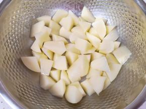 将土豆块放入盆里，加入少许盐和2勺橄榄油搅拌均匀，让每一块土豆上面都沾上盐和油。 