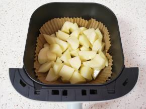 空气炸锅炸篮里面放上专用油纸，放入土豆块。 