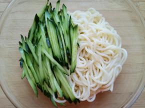 将黄瓜丝和煮好的面条放入凉拌汁里面。 