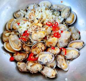切好的蒜粒、小米辣所有调味料倒入蚬子中拌匀