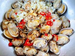 切好的蒜粒、小米辣所有调味料倒入蚬子中拌匀