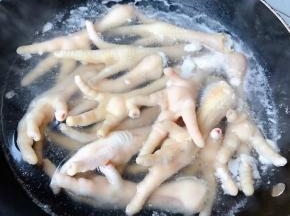 锅中烧开水倒入料酒放入凤爪焯水断生去除杂质和多余的油脂