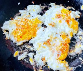 锅中倒入底油加热鸡蛋煎熟