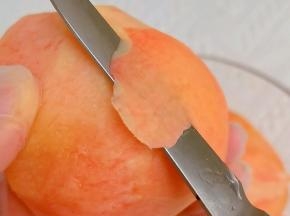 洗净的水蜜桃削皮。