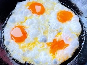 不粘锅加热倒入油，打入鸡蛋中火煎起来。