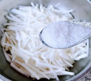 白萝卜切成粗细均匀的丝状，放入适量盐轻轻搓揉，腌制十分钟。