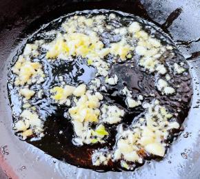 锅中倒入适量油加热，放入蒜粒爆香。