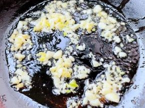 锅中倒入适量油加热，放入蒜粒爆香。
