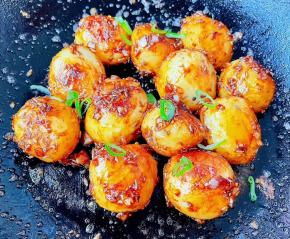 小土豆完全裹上调味料，最后撒上香葱即可出锅享用。