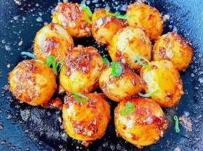 小土豆完全裹上调味料，最后撒上香葱即可出锅享用。