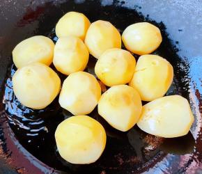 锅中倒入底油加热，放入晾凉的小土豆中火煎起来。