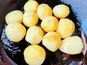 锅中倒入底油加热，放入晾凉的小土豆中火煎起来。
