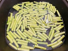 锅里烧水，水开后滴入几滴植物油，放入豆角煮5分钟至熟
