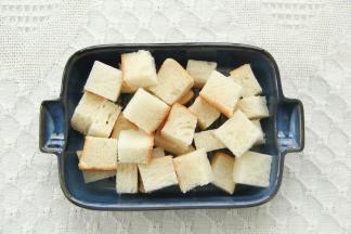 吐司切成合适的块（吐司比较薄，可以用3片），铺入烤碗。