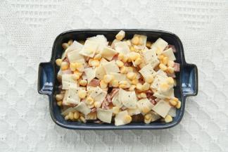 芝士片切成小块，均匀放在上方，撒上玉米粒。磨上适量黑胡椒碎。