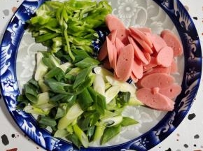 火腿肠切成片，青椒切成丝，葱切成段备用！